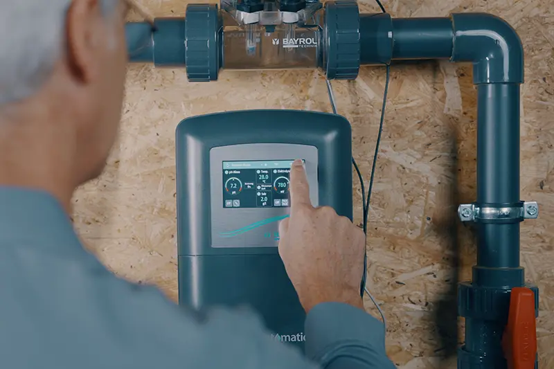 Mann mit einer Stoppuhr am Pool