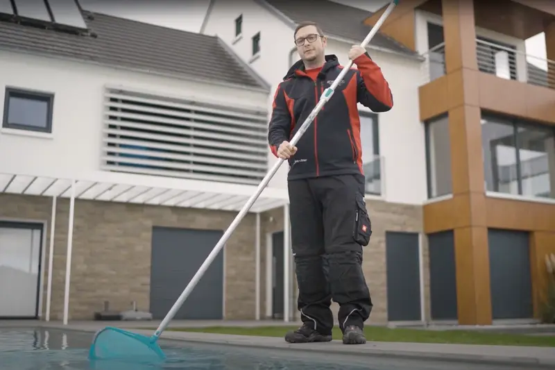 Mann mit einer Stoppuhr am Pool